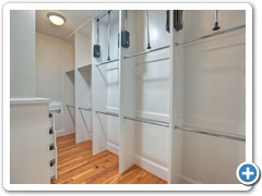 This closet has it all:  shelving, shoe racks, chest of drawers, and loads of fixed and pull down rods for all of your clothing.