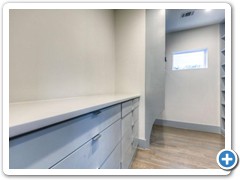 Master bedroom closet featuring enormous 8-drawer site-built chest with carrera marble top.